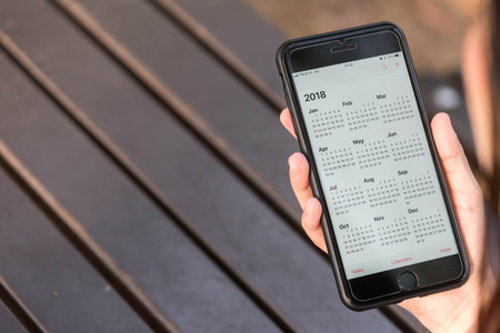 BANGKOK, THAILAND - NOVEMBER 26th, 2017: Hand of woman hold iphone 8 plus show calendar of 2018 on screenのeditorial素材