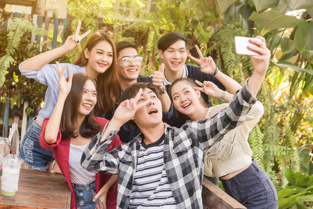 Group of six teenagers taking selfie with fun together in afternoonの写真素材