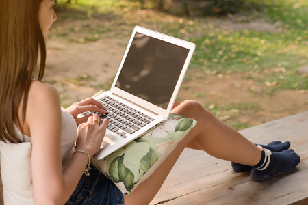 Beautiful asian woman teenager use laptop with blank screenの写真素材