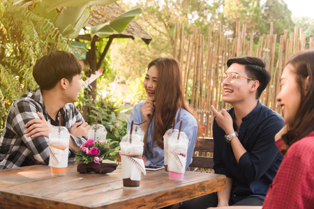 Group of 6 teenagers having fun together without liquor in cafe in afternoon drink milk tea, pink milk and chocolate in plastic glassの写真素材