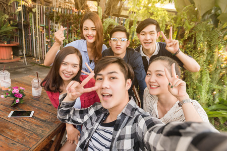 Group of six teenagers taking selfie with fun together in afternoonの写真素材