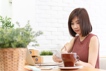 Woman small business owner, business start up conceptual, young entrepreneur work with laptop sell product online shopの写真素材