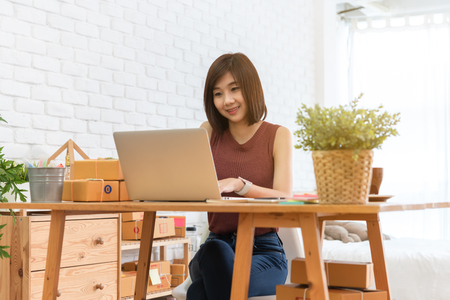 Woman small business owner, business start up conceptual, young entrepreneur check on laptop in the morning with coffee cupの写真素材