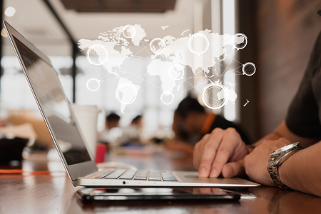Hand of man use smartphone and laptop with technology of globalization connectivity conceptualの写真素材