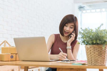 Woman small business owner, business start up conceptual, young entrepreneur work with laptop and smartphone take noteの写真素材