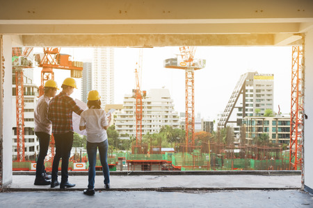 three construction engineers working together in construction site planning for the renovationの写真素材