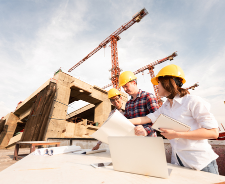 three construction engineers working together in construction site planning for the renovationの写真素材