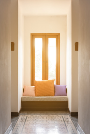 Relax corner with three pillow below window with beautiful sun lightの写真素材