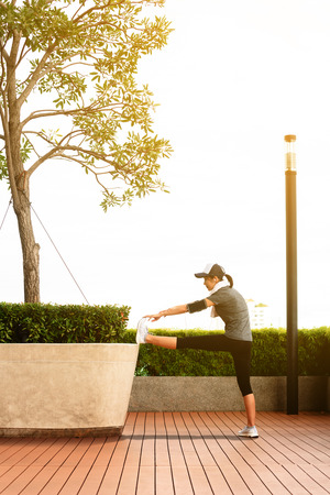 Young woman streching legs before work out in afternoonの写真素材