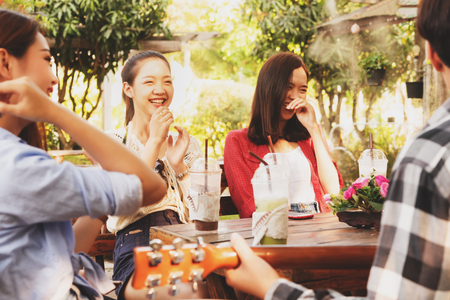 Group of six teenagers having fun together in coffee shop on the afternoonの写真素材