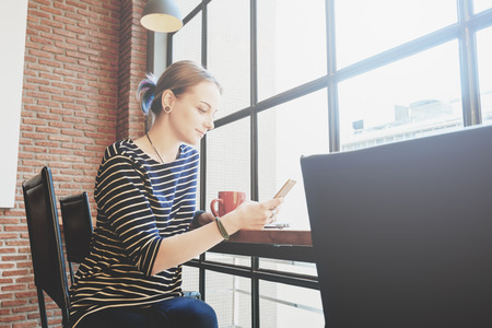 Woman freelance in coffee shop use smartphoneの写真素材