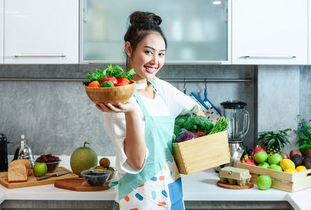 Woman in kitchen with various kind of vegetable and fruits that all are good for health and no meat, vegan lifestyle