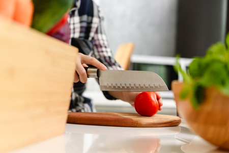 Healthy Young beautiful asian woman preparing vegetable for salad in kitchenの写真素材