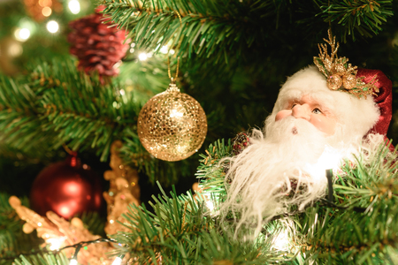 Close up christmas tree decorated with santa claus doll and christmas balls and lightの写真素材