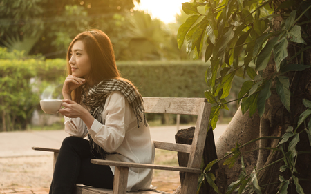 Beautiful young teenage woman freelance have a cup of latte on sun light, freelance lifestyle conceptualの写真素材