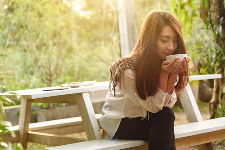 Beautiful young teenage woman freelance have a cup of latte on sun light, freelance lifestyle conceptualの写真素材