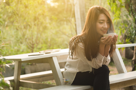 Beautiful young teenage woman freelance have a cup of latte on sun light, freelance lifestyle conceptualの写真素材