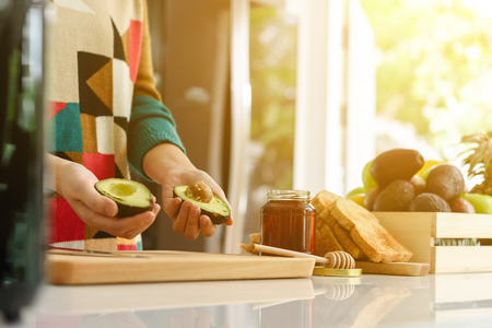 Young beautiful asian woman preparing avocado honey toast for breakfast in morningの写真素材