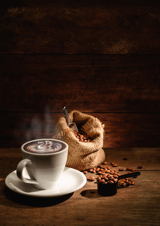 A cup of latte art with roasted coffee bean in bagの写真素材