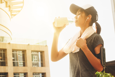 Young pretty woman finished running  drink water for refreshnessの写真素材