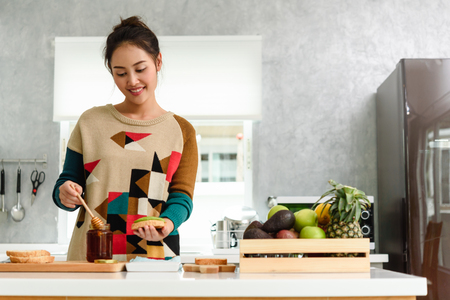 Healthy Young beautiful asian woman preparing avocado honey toast for breakfast in morningの写真素材