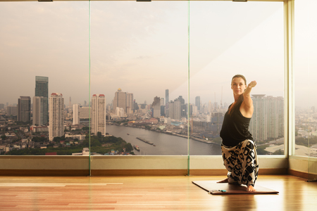 A yoga master practicing yoga performing Virabhadrasana poseの写真素材