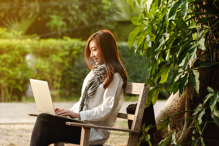 Beautiful young teenage woman freelance work with laptop on morning sun light, freelance lifestyle conceptualの写真素材