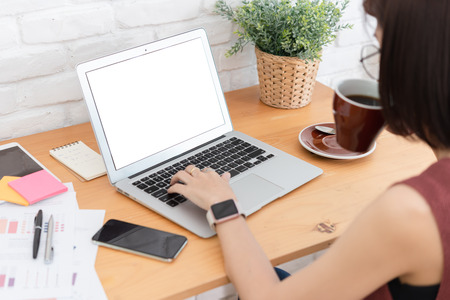 Woman small business owner, business start up conceptual, young entrepreneur work with laptop with white blank screen for display insertionの写真素材