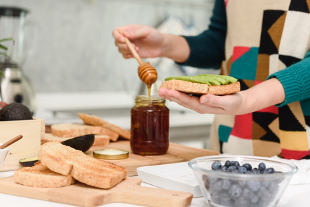 Healthy Young beautiful asian woman preparing avocado honey toast for breakfast in morningの写真素材