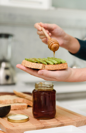 Healthy Young beautiful asian woman preparing avocado honey toast for breakfast in morningの写真素材