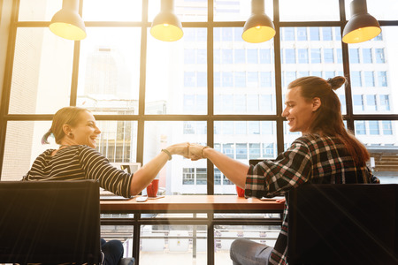 man and woman freelance make fist bump in coffee shop on one fine day in the afternoonの写真素材