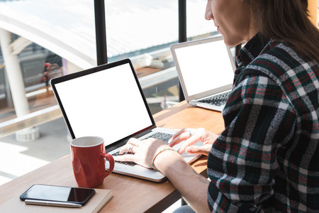 freelance working in coffee shop, Nomad worker conceptual, two white blank laptop screenの写真素材