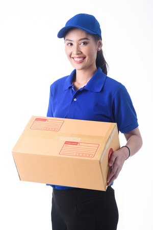 Beautiful young woman in blue uniform of delivery service, online shopping delivery conceptの写真素材