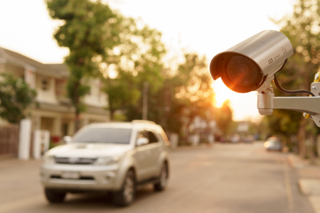 CCTV surveillance camera operation in village with house and cars run by