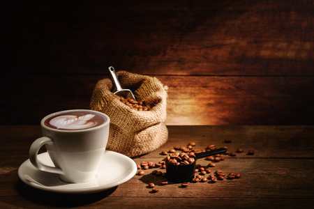 A cup of latte art with roasted coffee bean in bagの写真素材