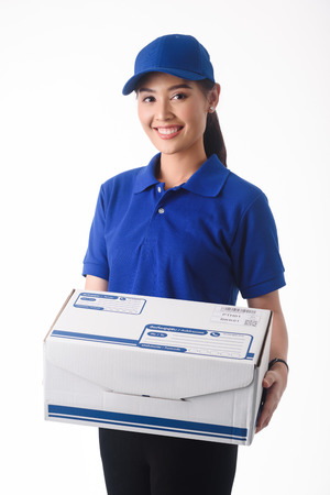 Beautiful young woman in blue uniform of delivery service, online shopping delivery conceptの写真素材