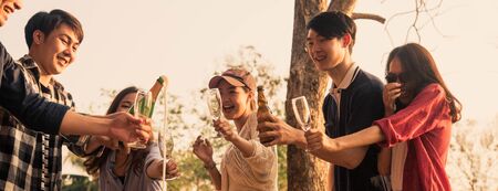 Hands of man in group of friends opening champange for celebrate, cropped dimension for bannerの写真素材