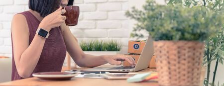 Woman small business owner, business start up conceptual, young entrepreneur check on laptop in the morning with coffee cupの写真素材