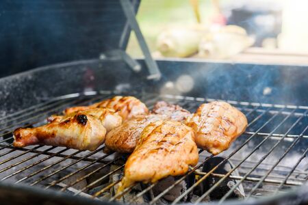 Roasted chicken drum stick, chest and sirloin beef with barbecue sauce on stoveの写真素材