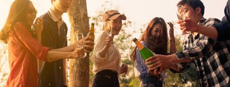 Hands of man in group of friends opening champange for celebrateの写真素材