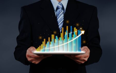 businessman holding tablet report on growth of business virtual chart. business strategic planning conceptual.の写真素材