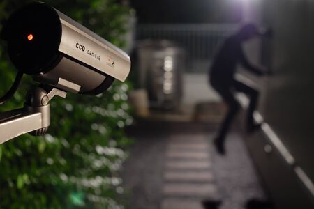 CCTV surveillance camera operate during night capture thief while break into a houseの写真素材