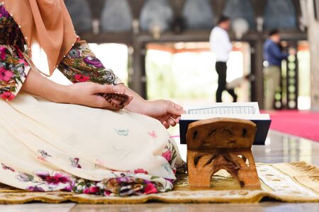 Muslim woman reading quran, the public holy book of islamic religion hold tasbeeh on the right handの写真素材
