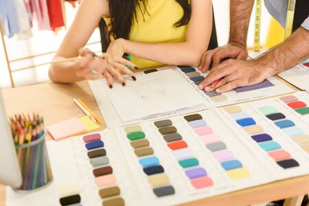Hands of two designer draw and sketch for new style of cloths