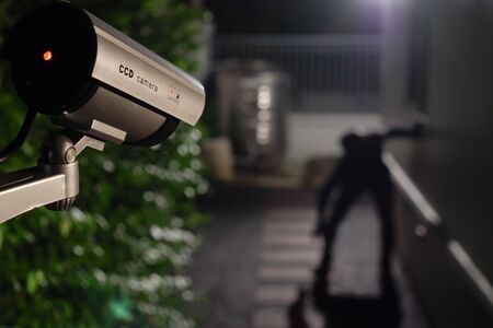 CCTV surveillance camera operate during night capture thief while break into a houseの写真素材
