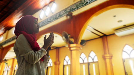 Silhoueitte of young muslim woman pray with beautiful sunset/ sunrise in backgroundのeditorial素材