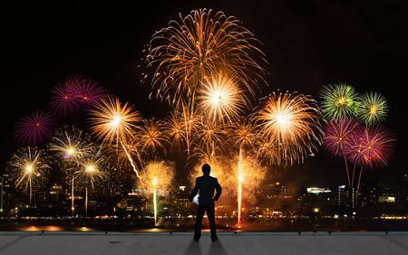 businessman stand on roof top of skyscrabber watching fireworks business success conceptual imageの写真素材