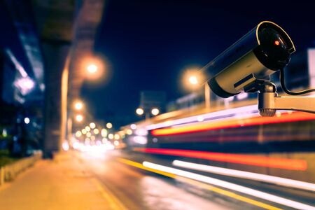 CCTV, Surveillance camera operating in city watching traffic road at nightの写真素材