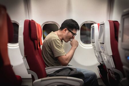 Man get sick during travel on airplane, possibility of corona virus outbreakの写真素材