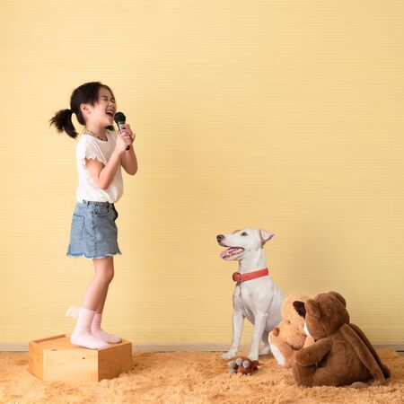 Cute little girl dream of being a super star performing concert for her pet and friend dollsの写真素材